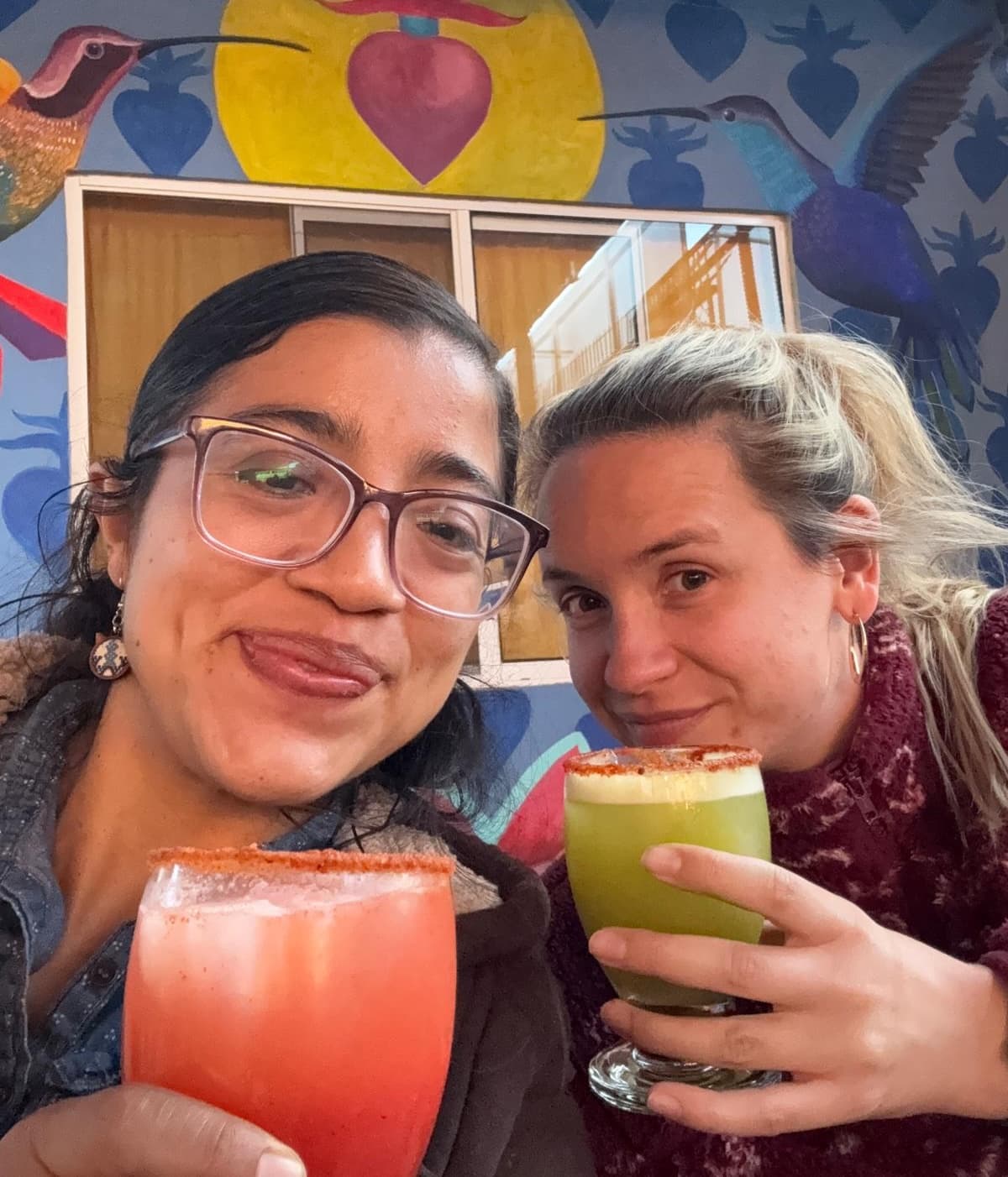 Spanish teacher and student enjoying mezcal cocktails at a colorful bar in Oaxaca