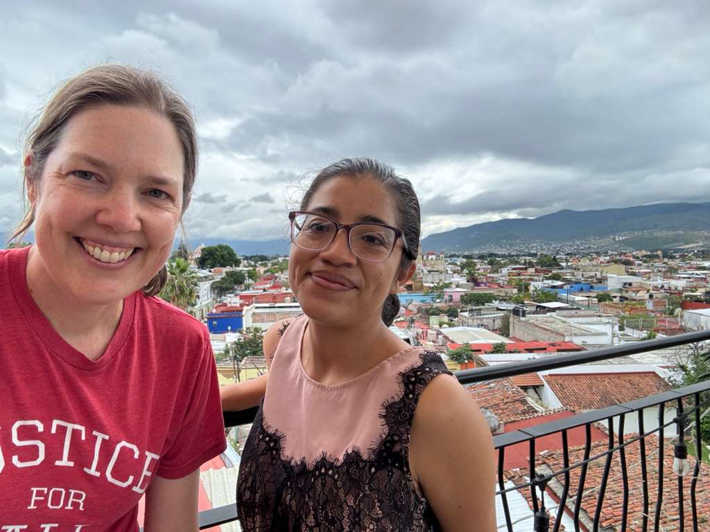 Spanish teacher and student on a rooftop terrace with panoramic mountain views over Oaxaca