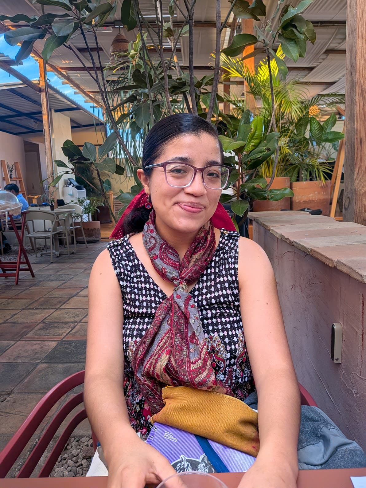 Yara, Spanish teacher in Oaxaca, sitting at a cafe surrounded by plants